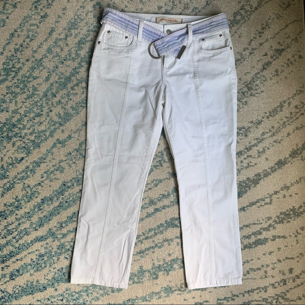 White jeans with front and back pockets and reversible belt.